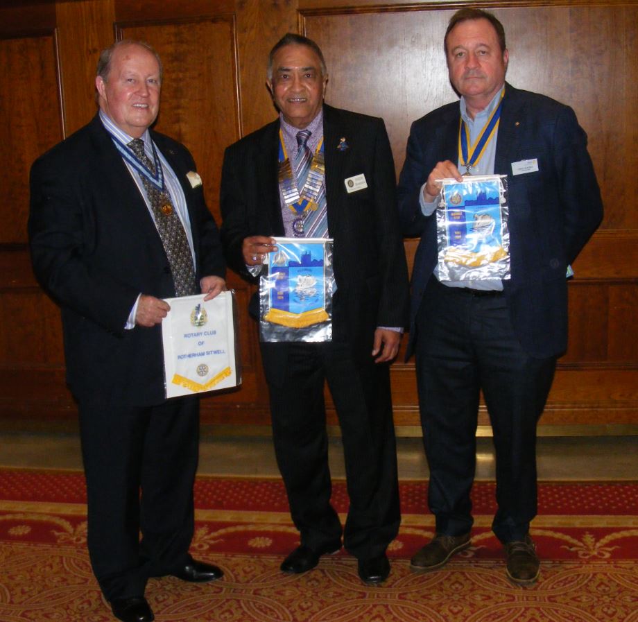 Visiting Rotarian Bill Hitchen, a Past President of the Rotary Club of Ellesmere, Shropshire exchanges pennants with President Yogesh Bhimpuria of Rotherham Sitwell and President Chris Holmes of Rotherham Club.